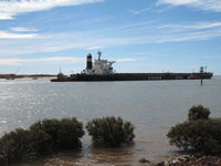 Tugs manoevring full ore carrier